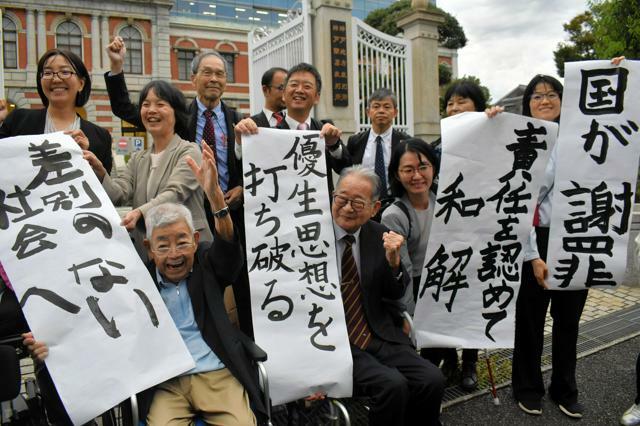 和解が成立し、「差別のない社会へ」などと書かれた紙を掲げる弁護団ら=2024年10月24日午後4時33分、神戸市中央区、原晟也撮影