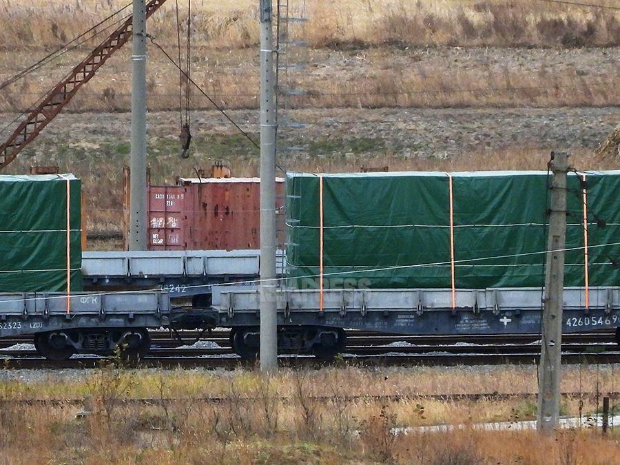 ロシアの無蓋台車の上には緑色のシートで梱包された貨物が。内容物は不明。