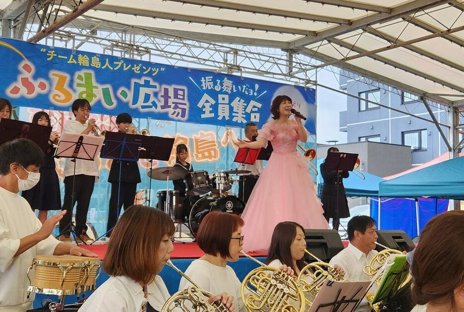 能登半島地震の復興支援イベント「“チーム輪島人プレゼンツ”振る舞いだョ！全員集合」で地元のブラスバンドと共演する水森かおり＝石川県輪島市