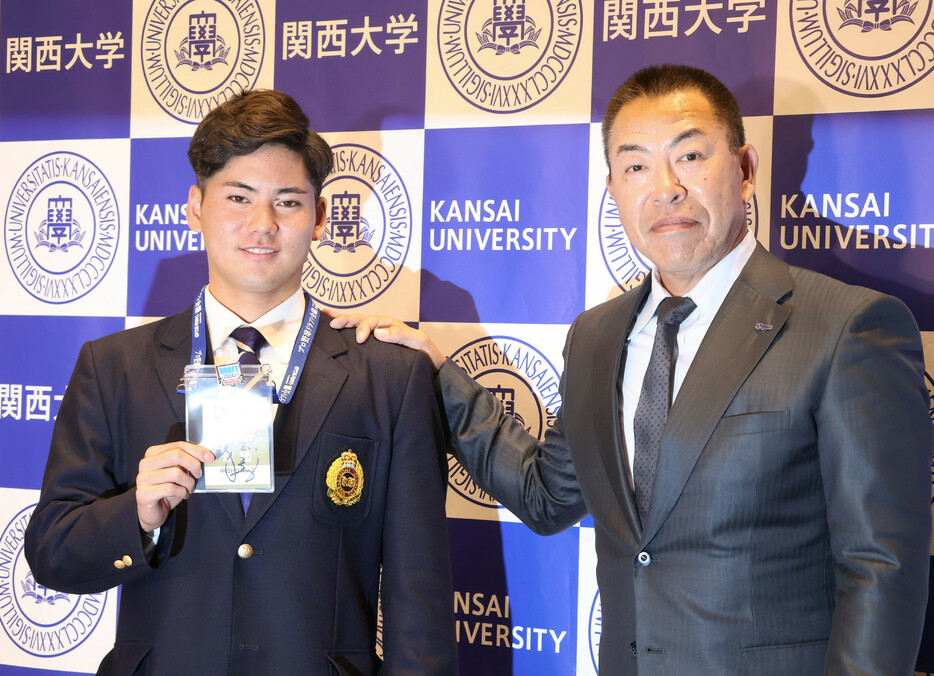 中日の井上一樹新監督（右）からドラフト１位の指名あいさつを受けた関大の金丸夢斗投手。「体に気を付けて息の長い選手になろうと言っていただいたので、その通り頑張る」と誓った＝２５日、大阪府吹田市