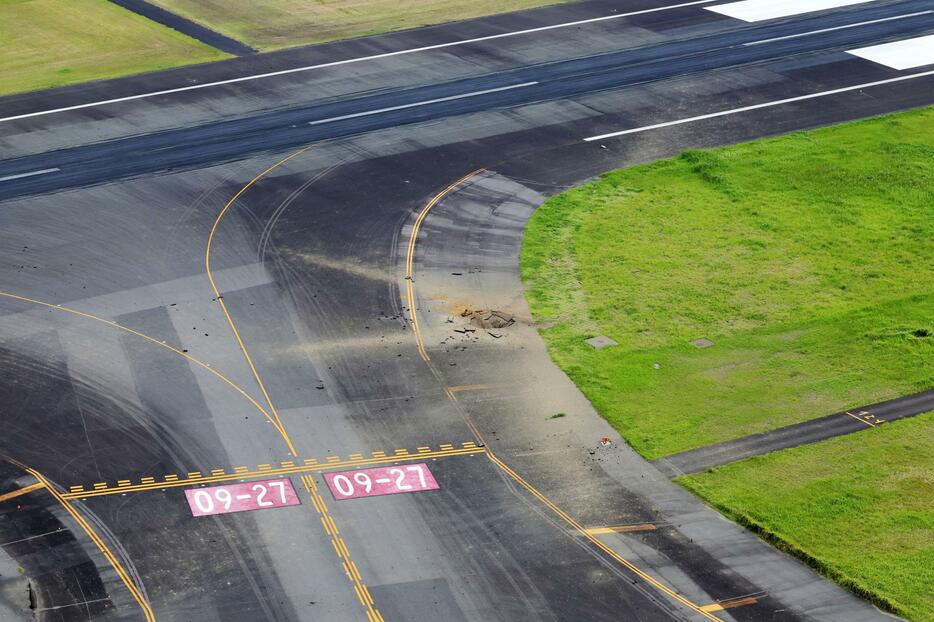 不発弾の陥没した宮崎空港の誘導路（中央）。奥は滑走路＝2日午後0時41分（共同通信社ヘリから）