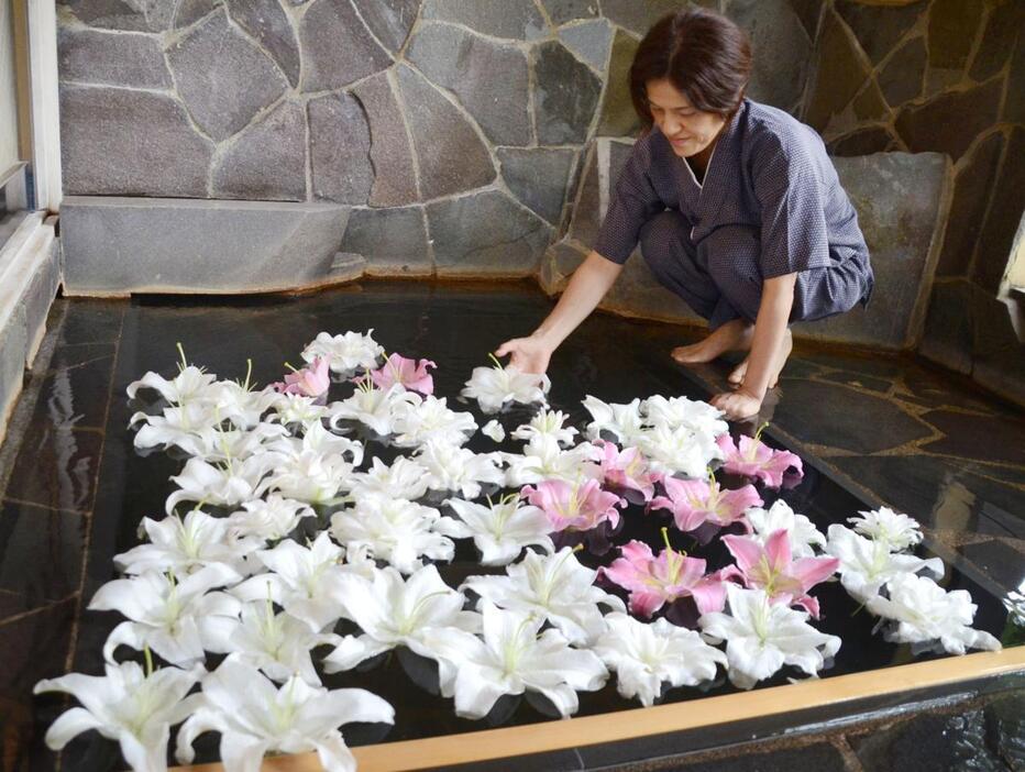 ユリの花が湯船を彩る露天風呂=10月4日、津南町上郷上田