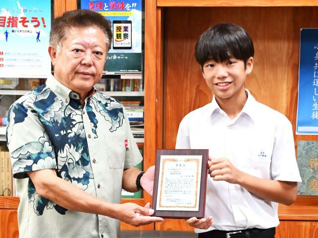 山内社長（左）から山下さんに表彰状と副賞が手渡された＝22日、北中学校