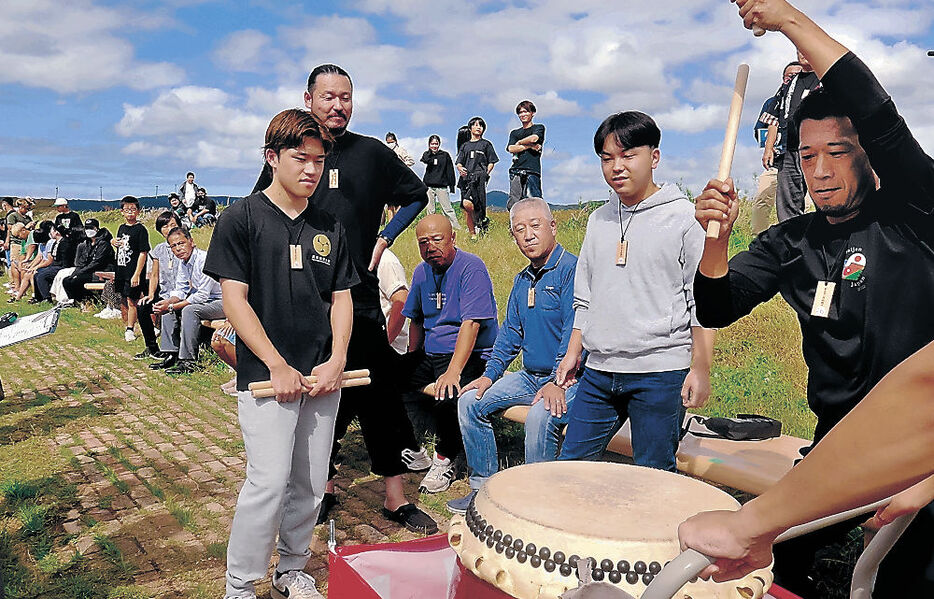 ギネス世界記録認定に向けて太鼓をたたく参加者＝志賀町富来領家町の「世界一長いベンチ」