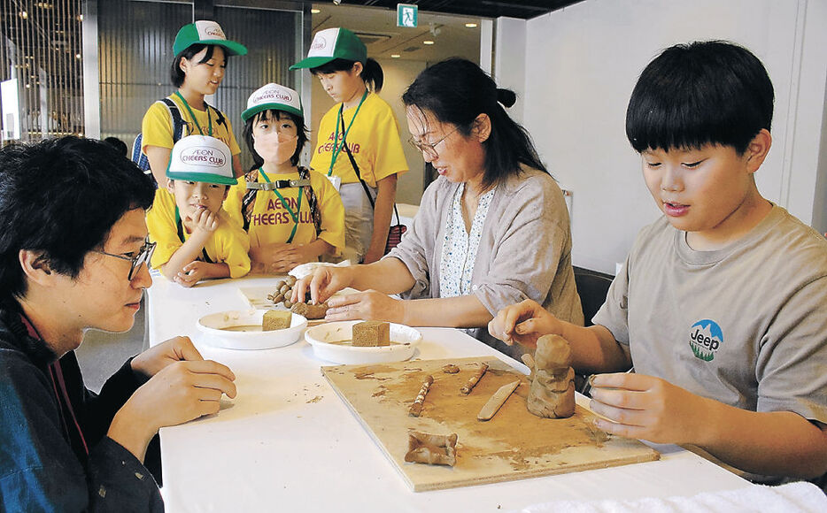 珠洲焼の制作体験を楽しむ親子連れ＝１２日午前１０時４５分、金沢市のしいのき迎賓館