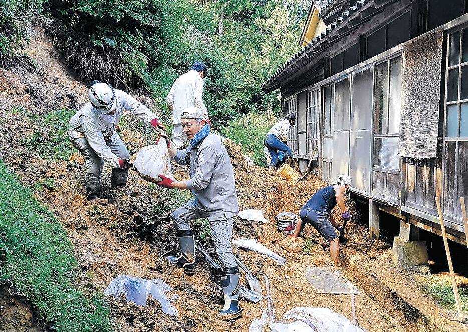 民家の敷地に流入した土砂を取り除くボランティア＝輪島市白米町