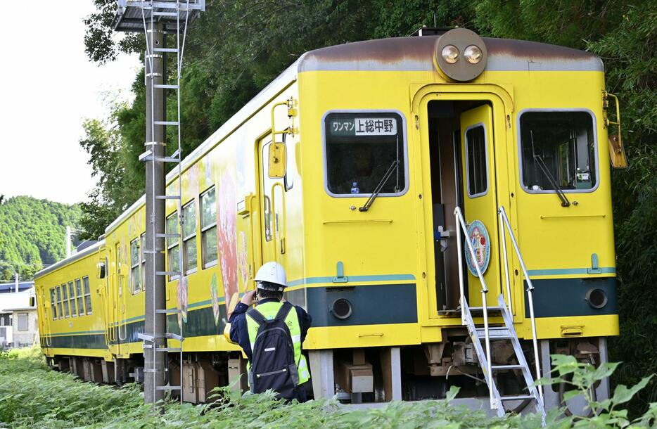 いすみ鉄道の脱線した車両を調べる運輸安全委員会の鉄道事故調査官＝4日午後、千葉県いすみ市