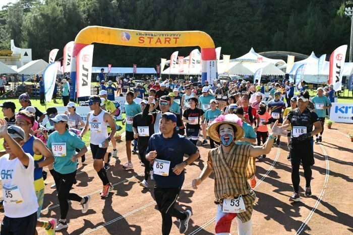 合図で一斉に走りだすフルマラソンコースのランナー＝19日午後3時、伊平屋村我喜屋の友愛と健康の広場（喜瀨守昭撮影）