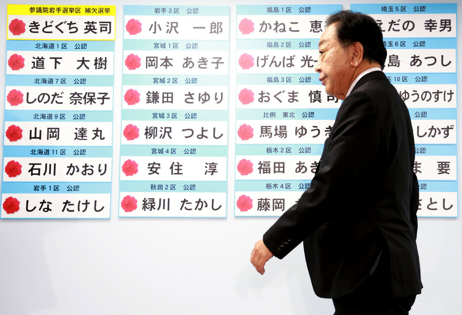 開票センターで当選確実となった候補者のボードの前を通る立憲民主党の野田佳彦代表＝２７日午後、東京・永田町の同党本部