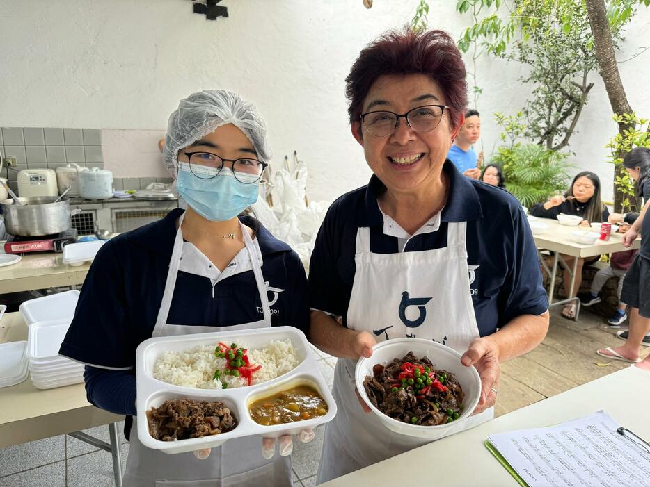 売れ行き抜群の牛丼とカレーセットと、牛丼を持つ千田会長