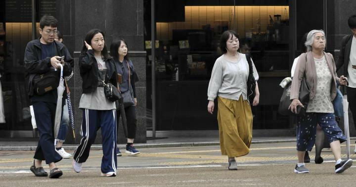 長袖の上着を着て歩く人たち＝3日午前、松山市大街道3丁目