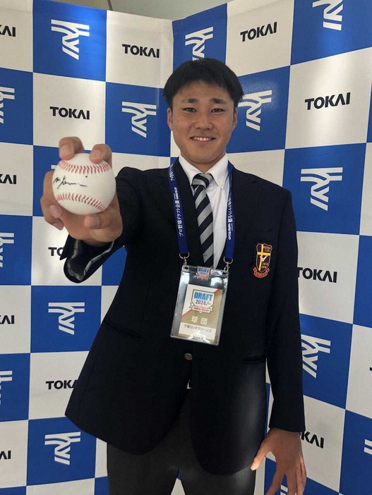 ロッテからドラフト5位指名された東海大九州・広池は吉井監督のサインボールを手に笑顔（球団提供）