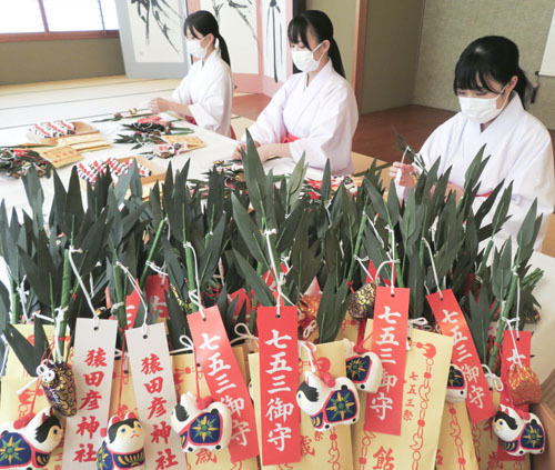 【子どもの健やかな成長を願いササに千歳飴などを取り付けるみこたち＝伊勢市の猿田彦神社で】