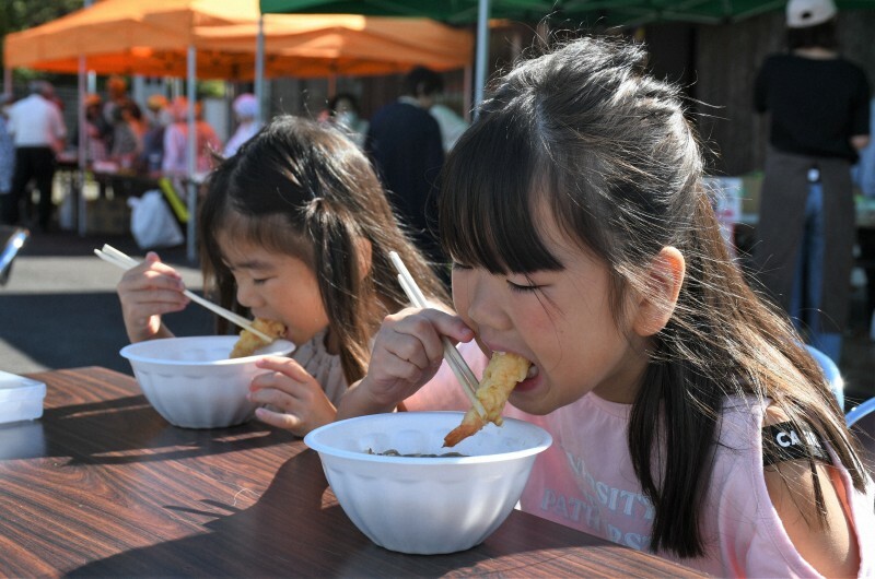 エビの天ぷらを頰張る子供＝滋賀県甲賀市土山町黒川で2024年10月13日、礒野健一撮影