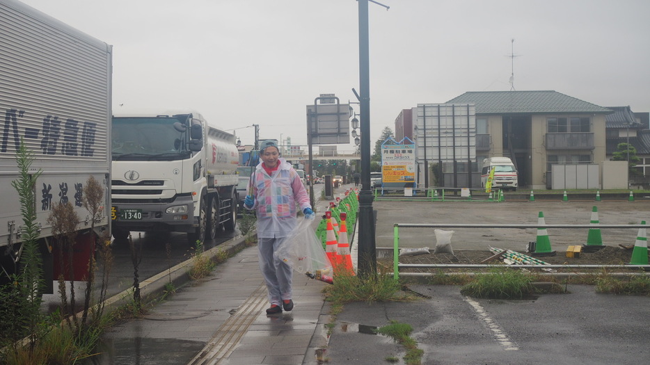 雨の中ゴミ拾いをしながら歩くオチロさん