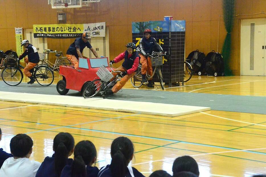 スタントマンによる事故の再現を見守る生徒ら＝横浜市都筑区の市立早渕中学校