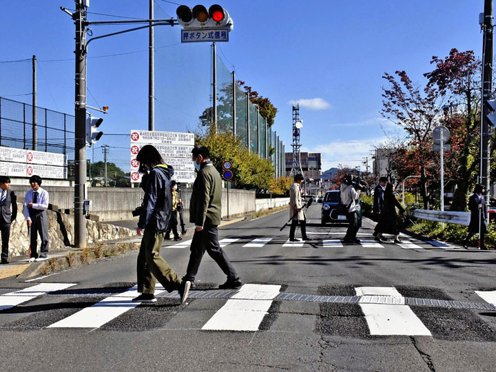 白線間隔が90センチに広がった横断歩道を歩き、視認性などを確かめる参加者＝福島市