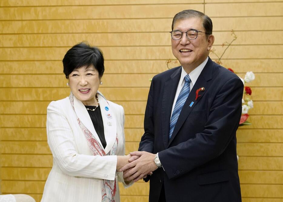 東京都の小池百合子知事（左）と握手する石破首相＝7日午後、首相官邸