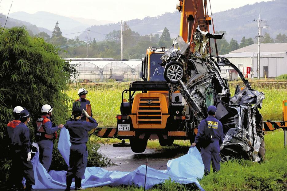 クレーンで川の中からつり上げられた車（23日午前8時26分、日南市で）