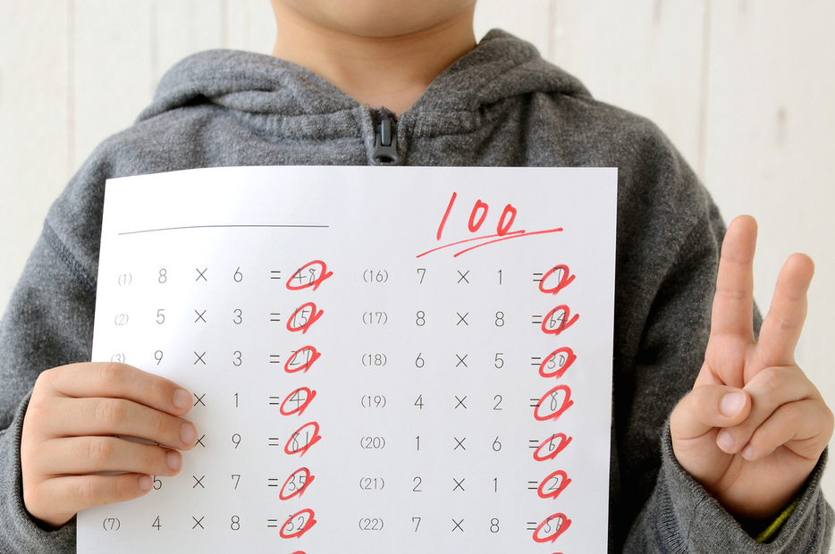 100点を取ってピースサインをする子どものイメージ写真（Takasuu / Getty Images/iStockphoto）