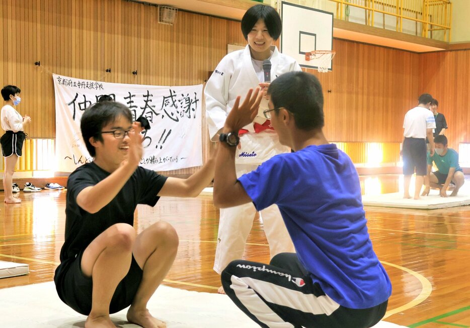 中村さんに見守られて後ろ受け身の練習をする生徒たち（福知山市私市・府中丹支援学校）