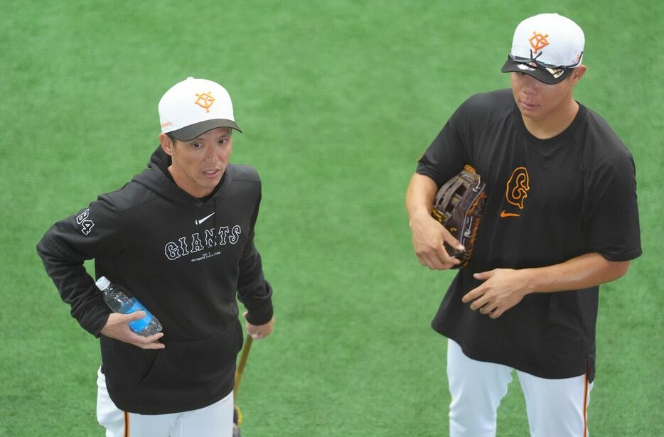 佐々木俊輔（右）と話す松本哲也外野守備走塁コーチ（カメラ・岡野　将大）