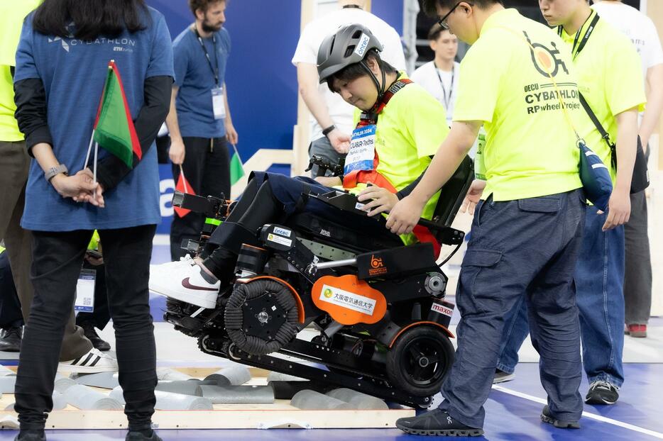 電動車いすレース決勝でデコボコ道の課題に挑戦するパイロットの小倉俊紀さん（撮影：越智貴雄）