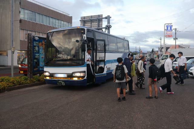 ＪＲ串間駅前で日南線の代替バスを利用する乗客ら＝２９日午後５時１３分、串間市西方