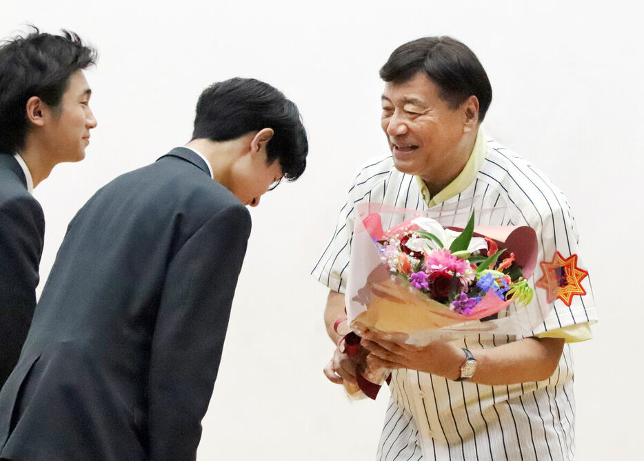 東北高野球部のユニホームと花束をプレゼントされた夢グループ・石田社長