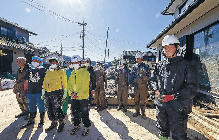 奥能登豪雨の犠牲者に黙とうを捧げるボランティア＝２１日午前１１時半、輪島市町野町