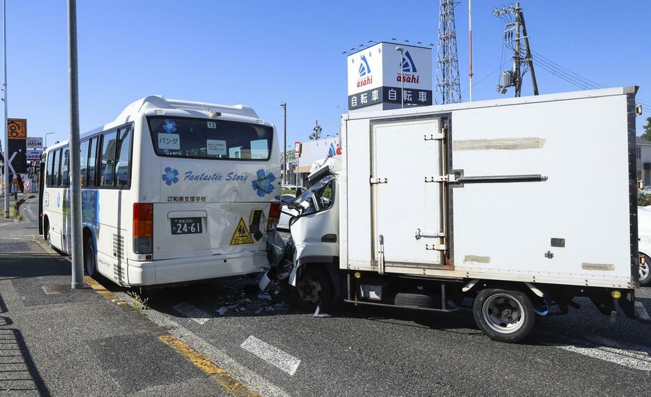 特別支援学校のスクールバス（左）に追突したトラック＝21日午前10時32分、大阪府高石市