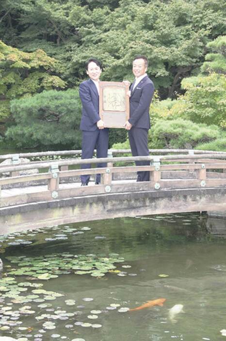 1961年まで3回行われた関門両市の親善野球の優勝盾を手にする下関市の前田晋太郎市長（右）と北九州市の武内和久市長＝17日、下関市長府黒門東町