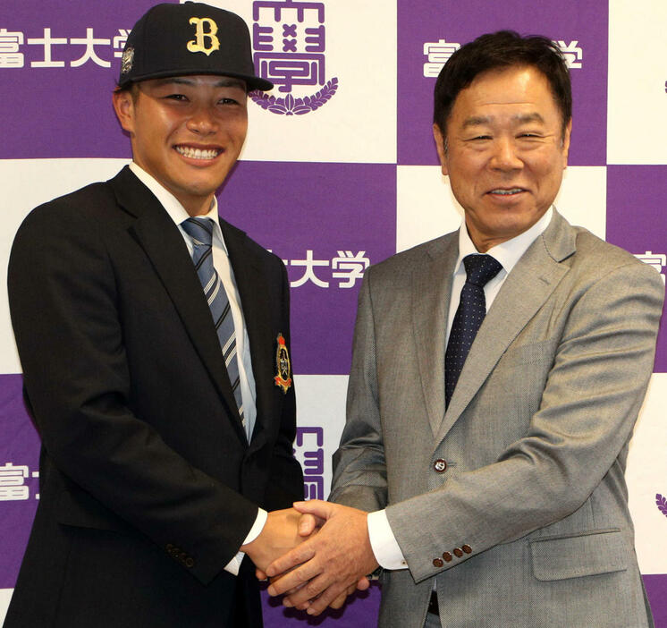 笑顔で握手をかわす富士大・麦谷（左）とオリックス福良GM（撮影・木村有優）