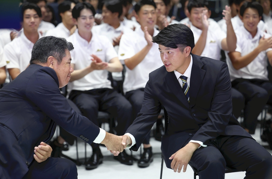 平井監督と握手を交わす中村投手（24日、愛知県豊田市で）