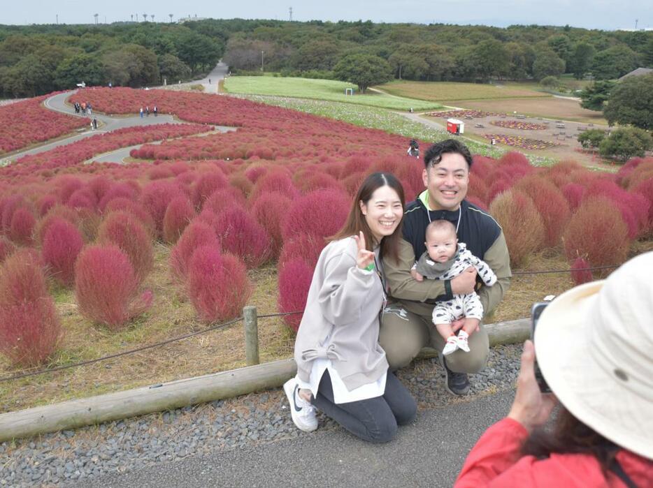 紅葉したコキアを背景に記念撮影する参加者=ひたちなか市馬渡