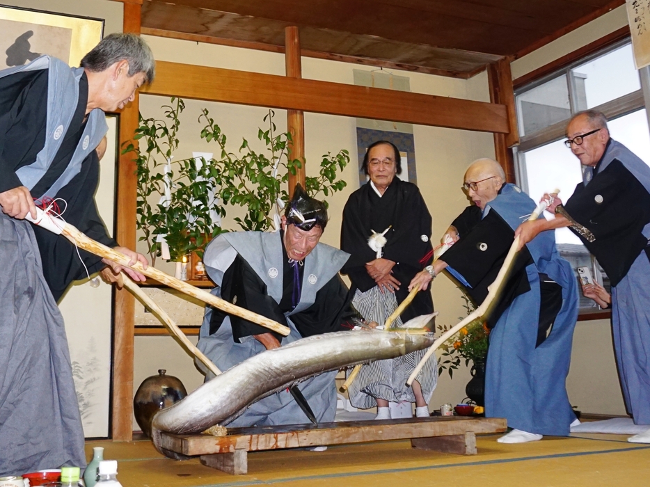 大蛇に見立てた鱧を退治する所作を見せる鱧切り役の白波瀬さんら＝兵庫県丹波篠山市沢田で