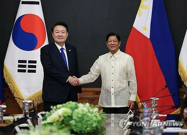 首脳会談で握手を交わす韓国の尹錫悦大統領（左）とフィリピンのマルコス大統領＝7日、マニラ（聯合ニュース）