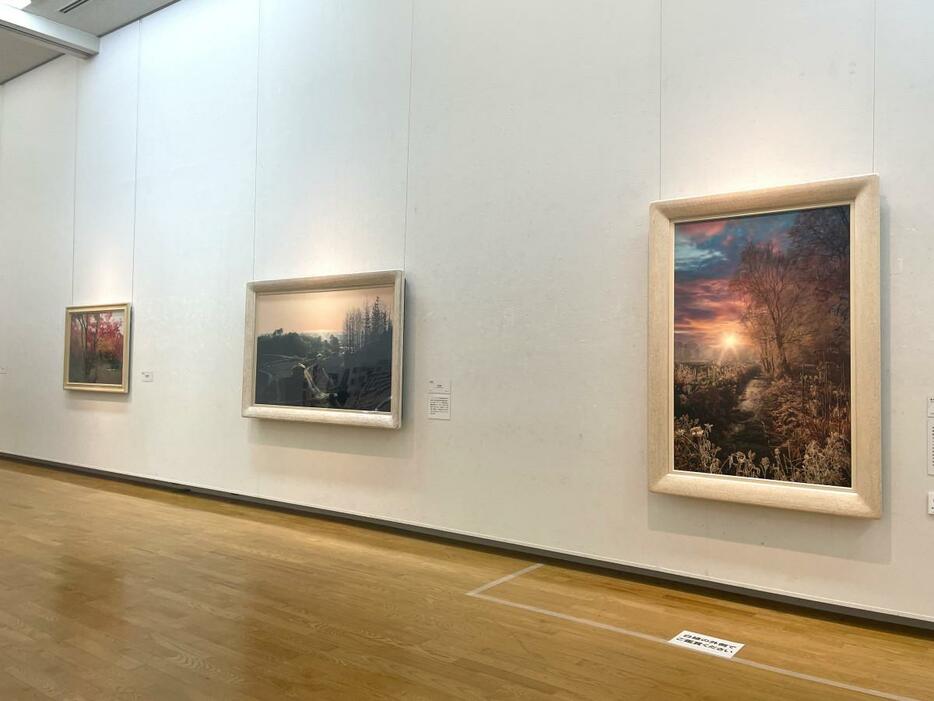 「ホキ美術館所蔵名品展 ～超絶リアリズム絵画～」会場、左：藤原 秀一「宝筐院秋図」（2011）、中：原 雅幸「光る海」（2010）、右：原 雅幸「冬のアンジェリカ」（2020）