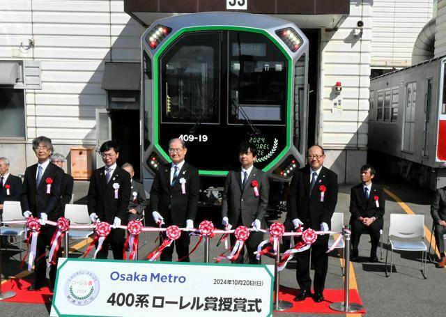 400系車両の前でテープカットをする大阪メトロや鉄道友の会などの関係者ら=2024年10月20日午前10時24分、大阪市住之江区、諏訪和仁撮影