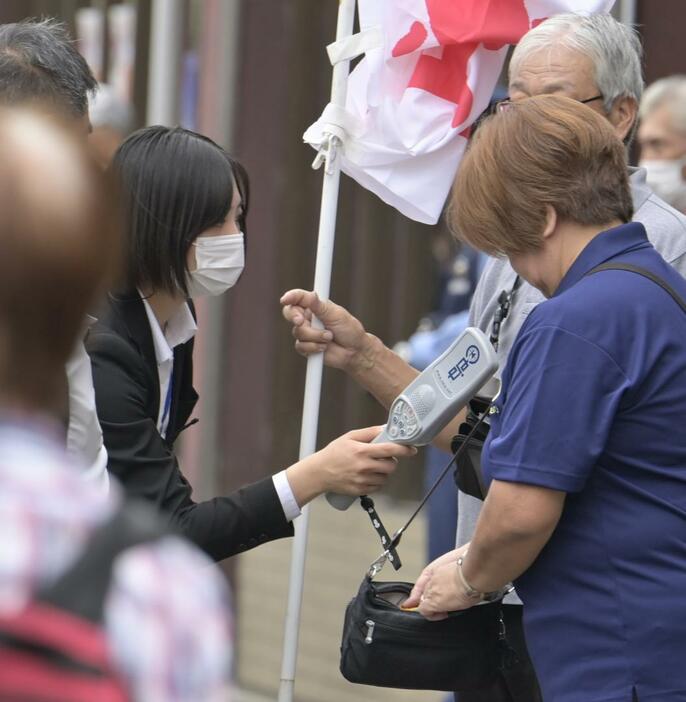 金属探知機や手荷物検査で警戒に当たる警察官(左)=取手市取手