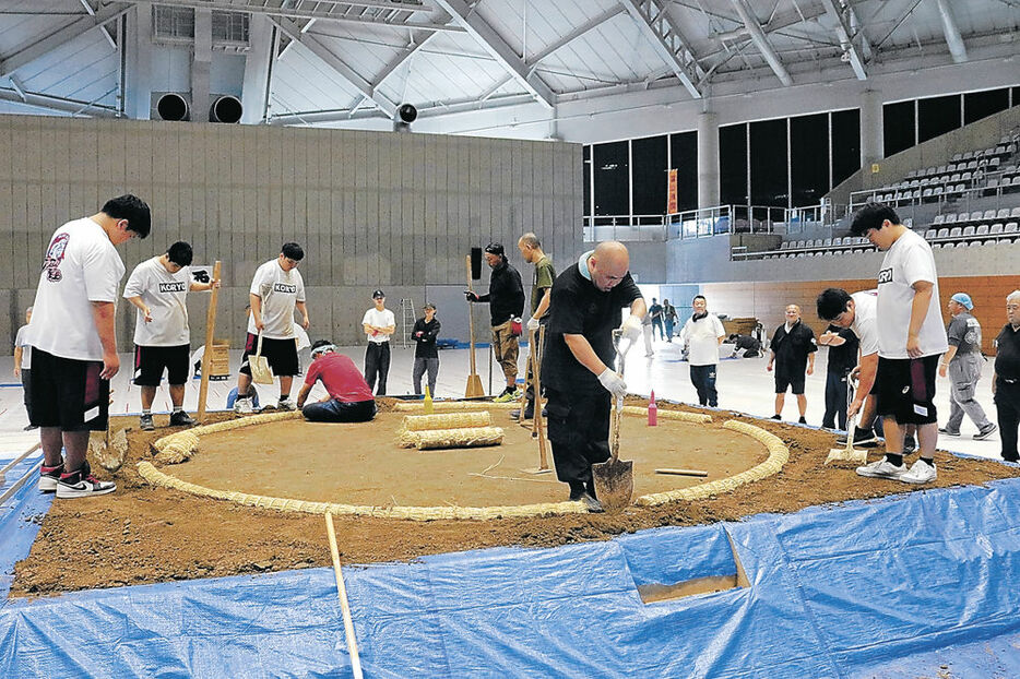 呼び出しとともに土俵をつくる高岡向陵高相撲部の生徒＝高岡市竹平記念体育館