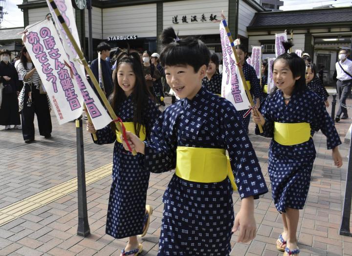 道後温泉駅前をパレードする児童