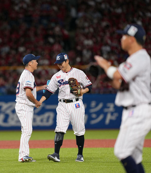 ヤクルト対広島　7回表を終え握手を交わすヤクルト石川（左）と青木（撮影・横山健太）