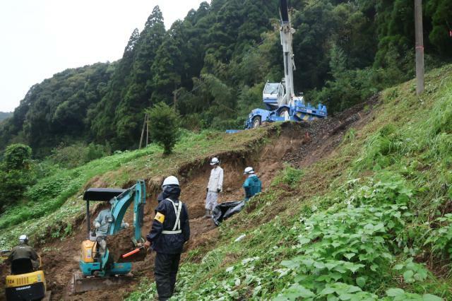 大雨によって線路近くで土砂崩れが発生し、復旧作業が続くＪＲ日南線＝２４日午後、串間市奈留