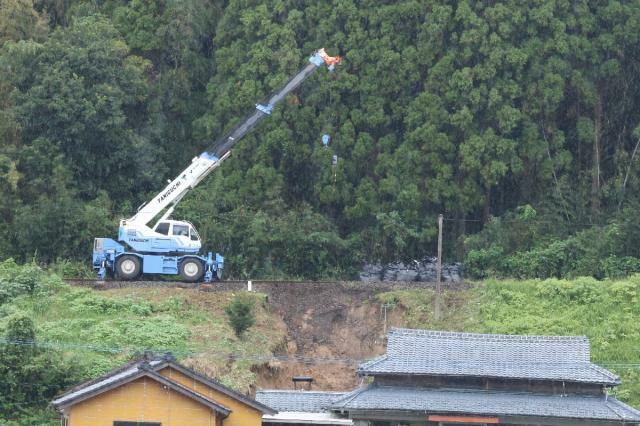 大雨によって線路近くで土砂崩れが発生し、復旧作業が続くＪＲ日南線＝２４日午後、串間市奈留