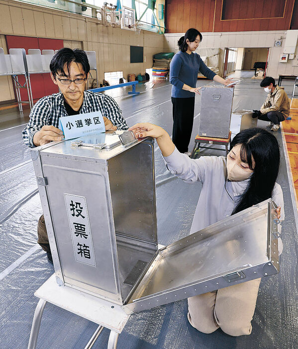 投票所を設置する職員＝２６日午前９時５０分、金沢市伏見台小