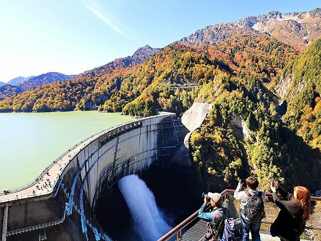 黒部ダムを包むように広がる秋色に染まった山肌