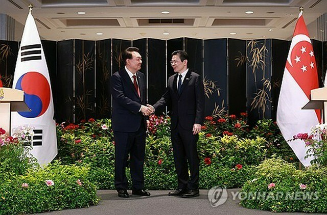 共同記者発表で握手を交わす韓国の尹錫悦大統領（左）とシンガポールのウォン首相＝8日、シンガポール（聯合ニュース）