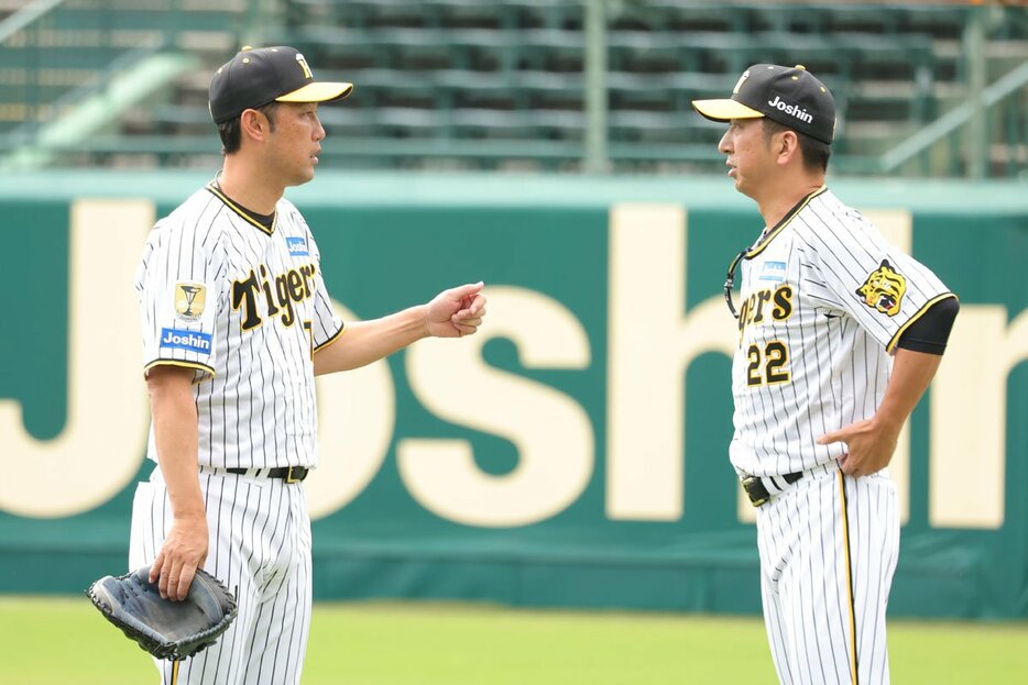 復帰した金村投手コーチ(左)と相談する阪神・藤川監督