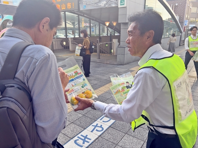 国消国産の啓発グッズを配るJA和歌山中央会の坂東会長（右）